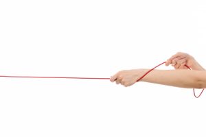 front-view-female-hand-pulling-up-red-rope-white